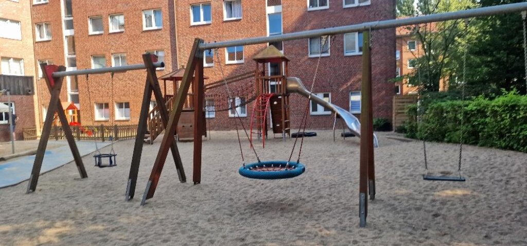 Die AWO Kita Auenstraße, Außengelände mit Rutsche und Schaukeln.