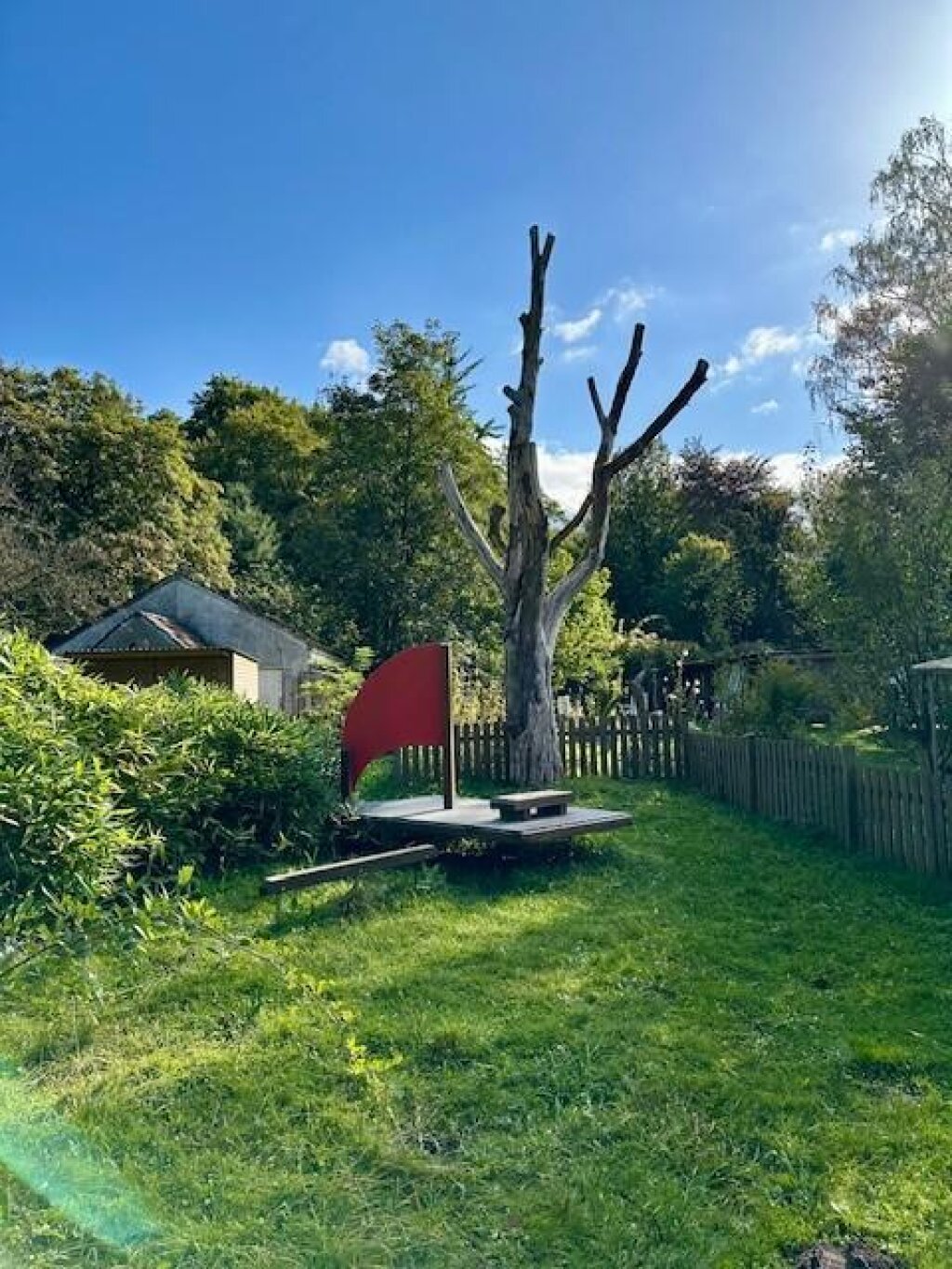 Außengelände mit Baum und Holzschiff der AWO Kita Hohenbuchen in Hamburg.