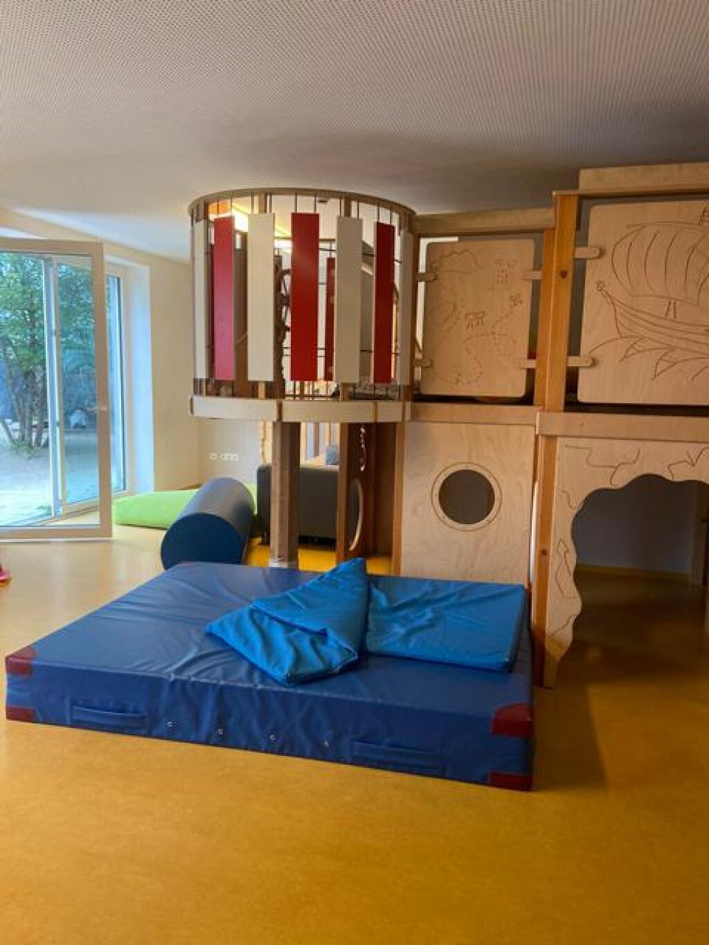 Gruppenraum der AWO Kita Am Inselpark mir Hochebene und Matte.